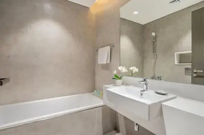 a bathroom with a sink and a bath tub and a sink at 1 Bedroom lagoon by District One in Dubai