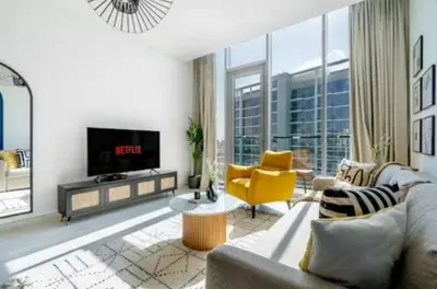 a living room with a couch and a yellow chair at 1 Bedroom lagoon by District One in Dubai