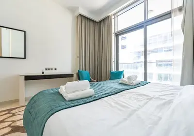 a bedroom with a bed with two towels on it at Chic 2BR in Damac Hills with Golf & Pool View in Dubai