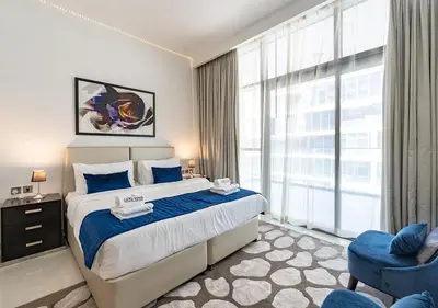 a bedroom with a large bed and a large window at Chic 2BR in Damac Hills with Golf & Pool View in Dubai