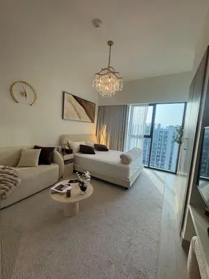 a white living room with a couch and a table at Luxury Studio Burj Khalifa View in Dubai