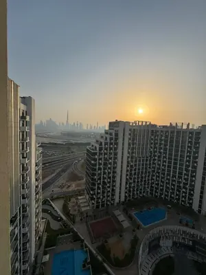 a view of a city with the sun setting behind buildings at Luxury Studio Burj Khalifa View in Dubai