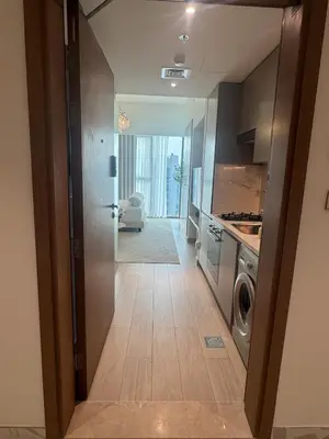a hallway leading to a kitchen with a washing machine at Luxury Studio Burj Khalifa View in Dubai