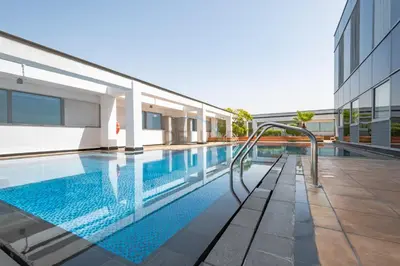a swimming pool next to a building at Iconic Views of the Future Museum, Minutes from Metro & Key Attractions, Sky Gardens, DIFC by Deluxe Holiday Homes in Dubai