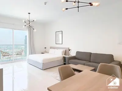 a white living room with a bed and a couch at Gorgeous Studio with balcony l Business Bay in Dubai