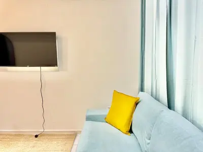 a blue couch with a yellow pillow next to a window at 5 mins walk to Burjuman metro in Dubai