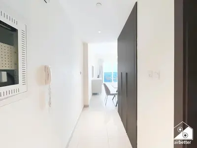 a hallway with a television and a phone on a wall at City-View Studio in AG Tower l Pool & Gym Access in Dubai