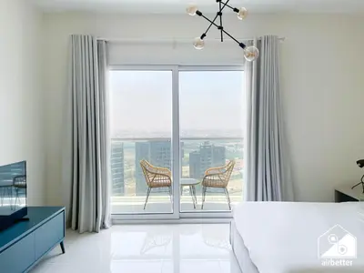 a bedroom with a bed and a table and chairs at City-View Studio in AG Tower l Pool & Gym Access in Dubai