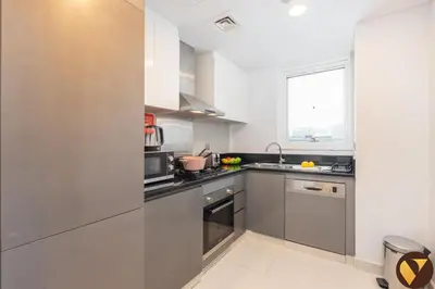 a kitchen with stainless steel appliances and a window at Vogue Business Bay Damac Maison Prive near Burj Khalifa and Dubai Mall, One Bedroom Apartment with Balcony, Canal and City Skyline View, Access to all Amenities in Dubai