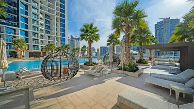 a patio with a swing and palm trees and a pool at Vogue Business Bay Damac Maison Prive near Burj Khalifa and Dubai Mall, One Bedroom Apartment with Balcony, Canal and City Skyline View, Access to all Amenities in Dubai