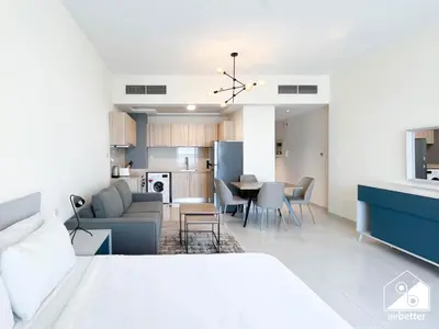 a bedroom with a bed and a living room and a kitchen at Skyline Studio Escape l Balcony , Gym & Pool in Dubai