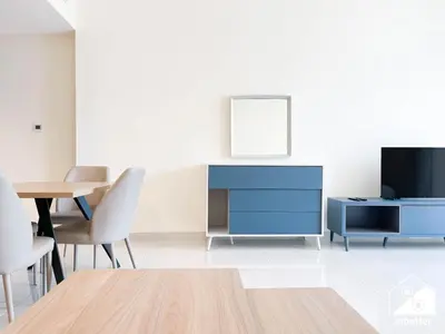 a living room with a blue cabinet and a table at Skyline Studio Escape l Balcony , Gym & Pool in Dubai