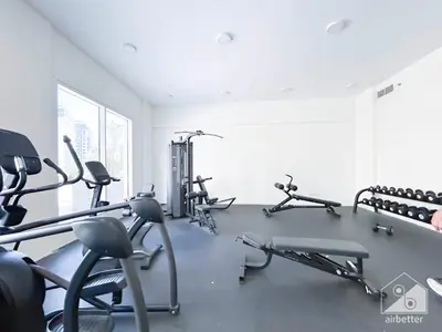 a gym with several treadmills and exercise bikes at Skyline Studio Escape l Balcony , Gym & Pool in Dubai