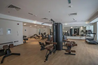 a gym with a lot of treadmills and machines at 5 Min to Dubai Mall Lux Stay Tennis Court in Dubai