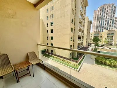 a balcony with two chairs and a view of a building at The Greens very well-lit unit in Dubai