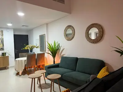 a living room with a couch and tables and mirrors at 1 min to ADCB metro New home in Dubai