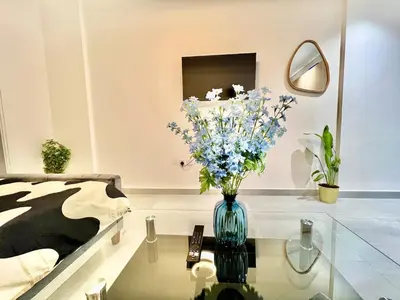 a room with a vase of flowers on a glass table at 3 mins walk to ADCB metro in Dubai