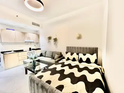 a bedroom with a bed and a living room at 3 mins walk to ADCB metro in Dubai
