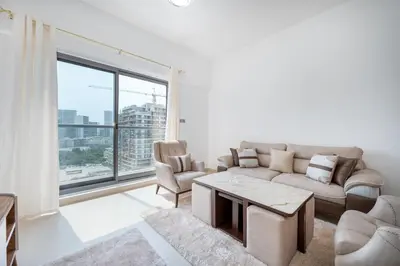 a living room with a couch and a large window at Contemporary 1BHK with Home Feel in Dubai