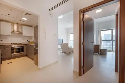 a kitchen with a door leading to a living room at Contemporary 1BHK with Home Feel in Dubai