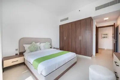 a bedroom with a large bed and a wooden cabinet at Contemporary 1BHK with Home Feel in Dubai