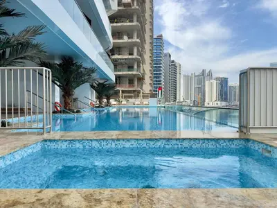 a large swimming pool in the middle of a city at Modern 1BR with Private Jacuzzi in Business Bay in Dubai