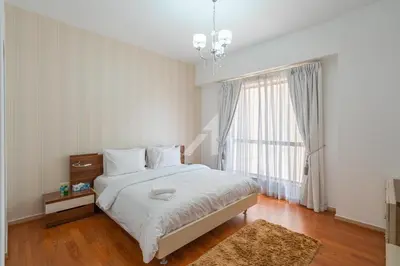 a bedroom with a bed and a large window at Rimal 4 in Dubai