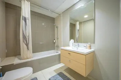 a bathroom with a toilet and a sink and a tub at 1BHK Retreat Peaceful & Bright in Dubai