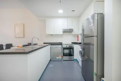 a kitchen with white cabinets and stainless steel appliances at 1BHK Retreat Peaceful & Bright in Dubai