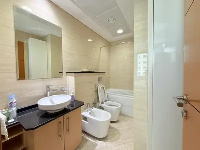 a bathroom with a sink and a toilet and a mirror at Ocean Heights New 2BDR with full Sea & Dubai Eye view in Marina by Simplex Home in Dubai