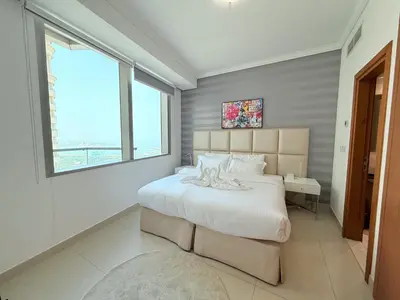 a bedroom with a large bed with a large window at Ocean Heights New 2BDR with full Sea & Dubai Eye view in Marina by Simplex Home in Dubai