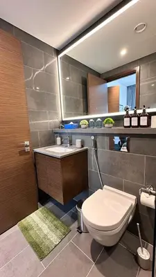 a bathroom with a toilet and a sink at Lux Sobha Hartland 1 BR with 5 Star Resort Amenities in Dubai