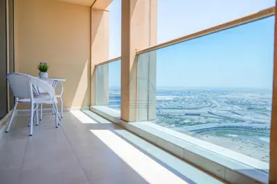 a balcony with a table and a large window at Luxury 2BR with Burj and Ocean Views in Dubai