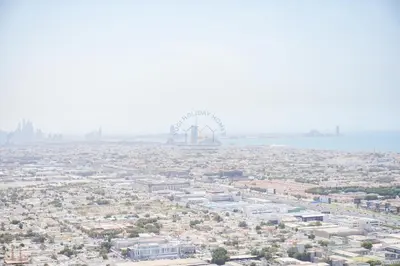 an aerial view of a city with a ferris wheel in the background at Luxury 2BR with Burj and Ocean Views in Dubai