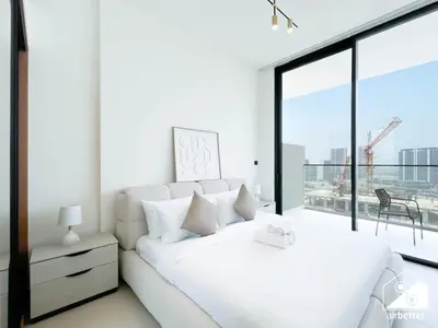 a white bedroom with a bed and a large window at Luxury & Comfort 1B at Binghatti Amber & Balcony in Dubai