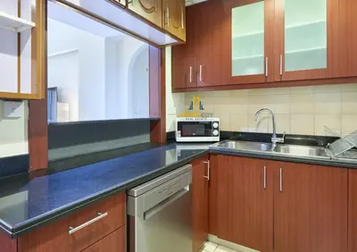 a kitchen with a sink and a microwave at Beachfront 2BR, Sea & Ain Dubai View, JBR Walk Hosted by Desert City Stays in Dubai