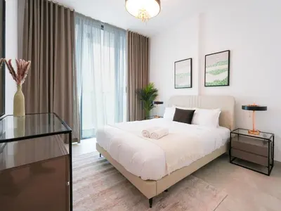a bedroom with a large white bed and a glass table at Luxury Smart 1BR -High Floor Business Bay Views in Dubai
