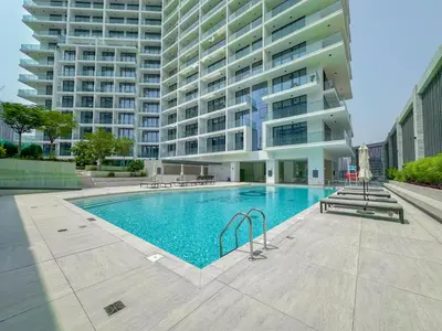 a swimming pool in front of a large building at Luxury Smart 1BR -High Floor Business Bay Views in Dubai