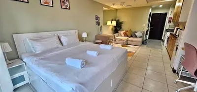 a bedroom with a large white bed with two pillows on it at Higuests - Close to METRO Charming Studio with Lake Views in Dubai