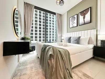 a bedroom with a large bed and a large window at 2BR Creekfront in Shobha Hartland Modern & Bright in Dubai