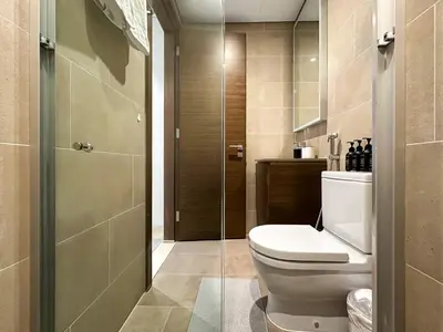 a bathroom with a toilet and a glass shower door at 2BR Creekfront in Shobha Hartland Modern & Bright in Dubai