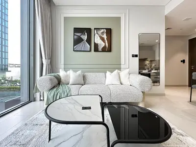 a living room with a couch and a table at 2BR Creekfront in Shobha Hartland Modern & Bright in Dubai