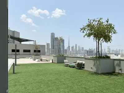 a view of a building with a green lawn at 2BR Creekfront in Shobha Hartland Modern & Bright in Dubai