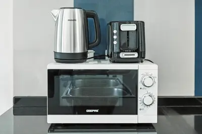 a microwave with a coffee maker on top of it at 1BR at Ocean Heights Next to Tram Station in Dubai