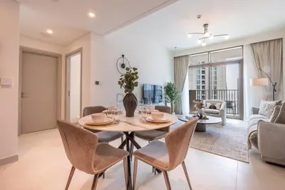 a dining room and living room with a table and chairs at Harbourfront Views 1BR, Near Park and Minutes from Festival City Mall, Creek Palace, Dubai Creek Harbour by Deluxe Holiday Homes in Dubai