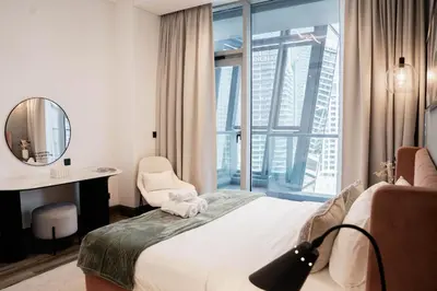 a hotel room with a bed and a desk and a window at Cozy 1BR with Canal Views in Business Bay in Dubai