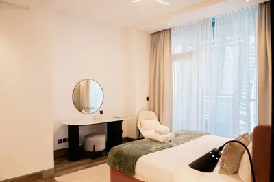 a bedroom with a bed and a desk and a mirror at Cozy 1BR with Canal Views in Business Bay in Dubai