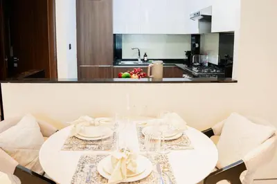 a white table with plates and napkins on it in a kitchen at Cozy 1BR with Canal Views in Business Bay in Dubai