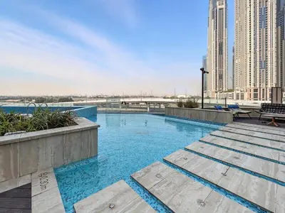 a large swimming pool in a city with tall buildings at BLVD - Urban Oasis Missoni 10 - Min to Dubai Mall in Dubai