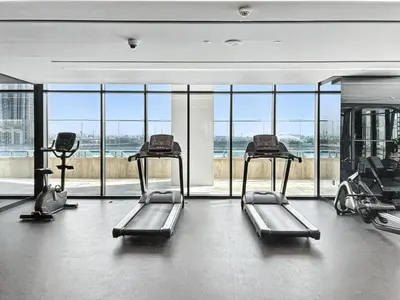 a gym with three tread machines and a large window at BLVD - Urban Oasis Missoni 10 - Min to Dubai Mall in Dubai